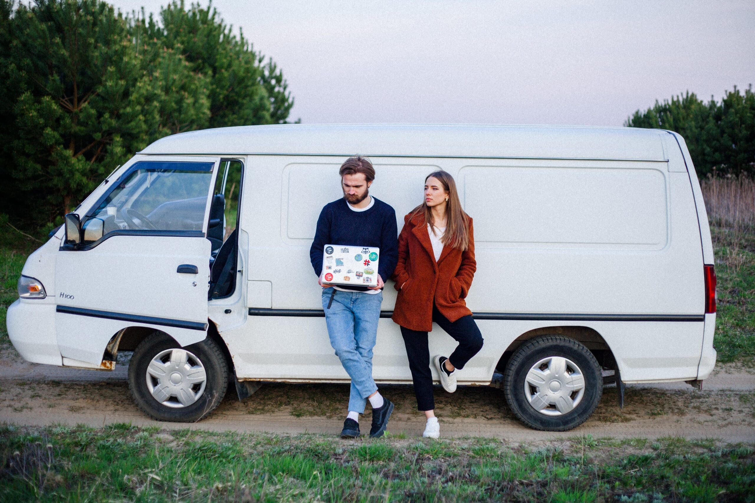 2 people stood in front of a white van